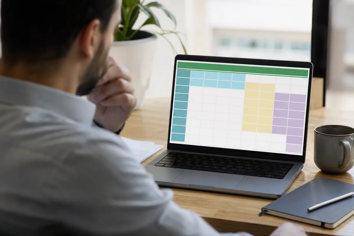 Analyst at a desk reviewing a spreadsheet of scraped rows